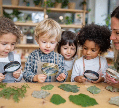 Kindergartenkinder experimentieren mit Naturmaterialien und Lupe