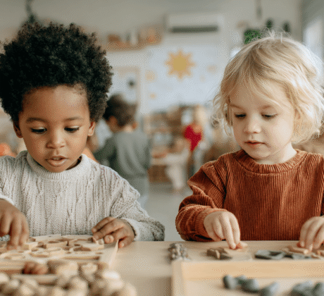 kinder, etwa 2 jahre in freiarbeit mit verschiedenen formen am tisch, Symbol für bildungsarbeit trotz personalmangel