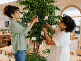 Erzieherinnen hängen Wunschzettel an Baum in Kita