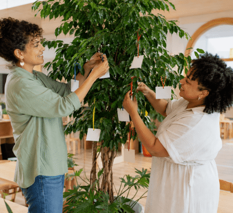 Erzieherinnen hängen Wunschzettel an Baum in Kita