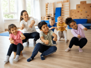 Kinder und Erzieherin spielen Auto-Bewegungsspiel im Turmraum der Kita