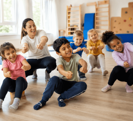 Kinder und Erzieherin spielen Auto-Bewegungsspiel im Turmraum der Kita