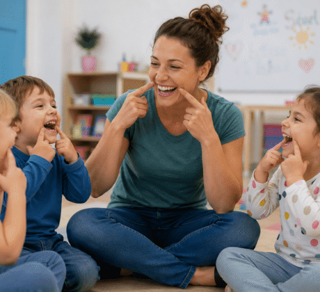 Erzieherin macht Lach-Yoga-Übungen mit Kindern ihrer Kita-Gruppe